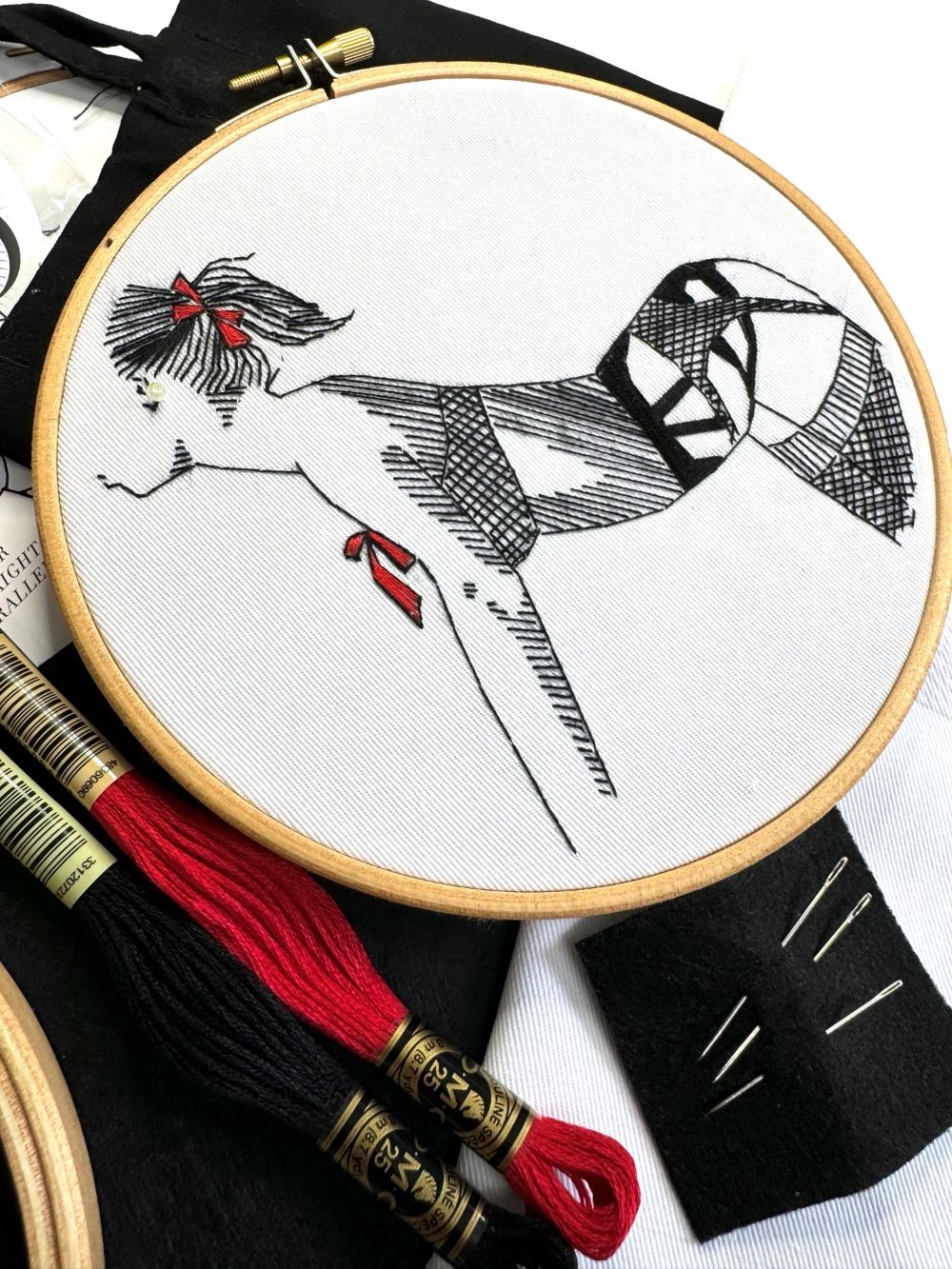 close up detail of embroidery kit with fishnet tights