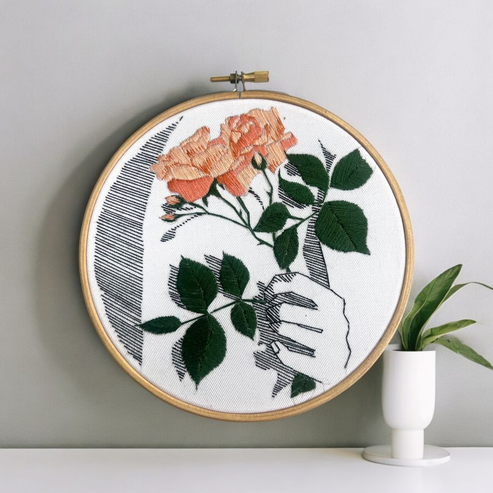 embroidery pattern PDf with floral detail in satin stitch and back stitch against wall background with flower vase detail