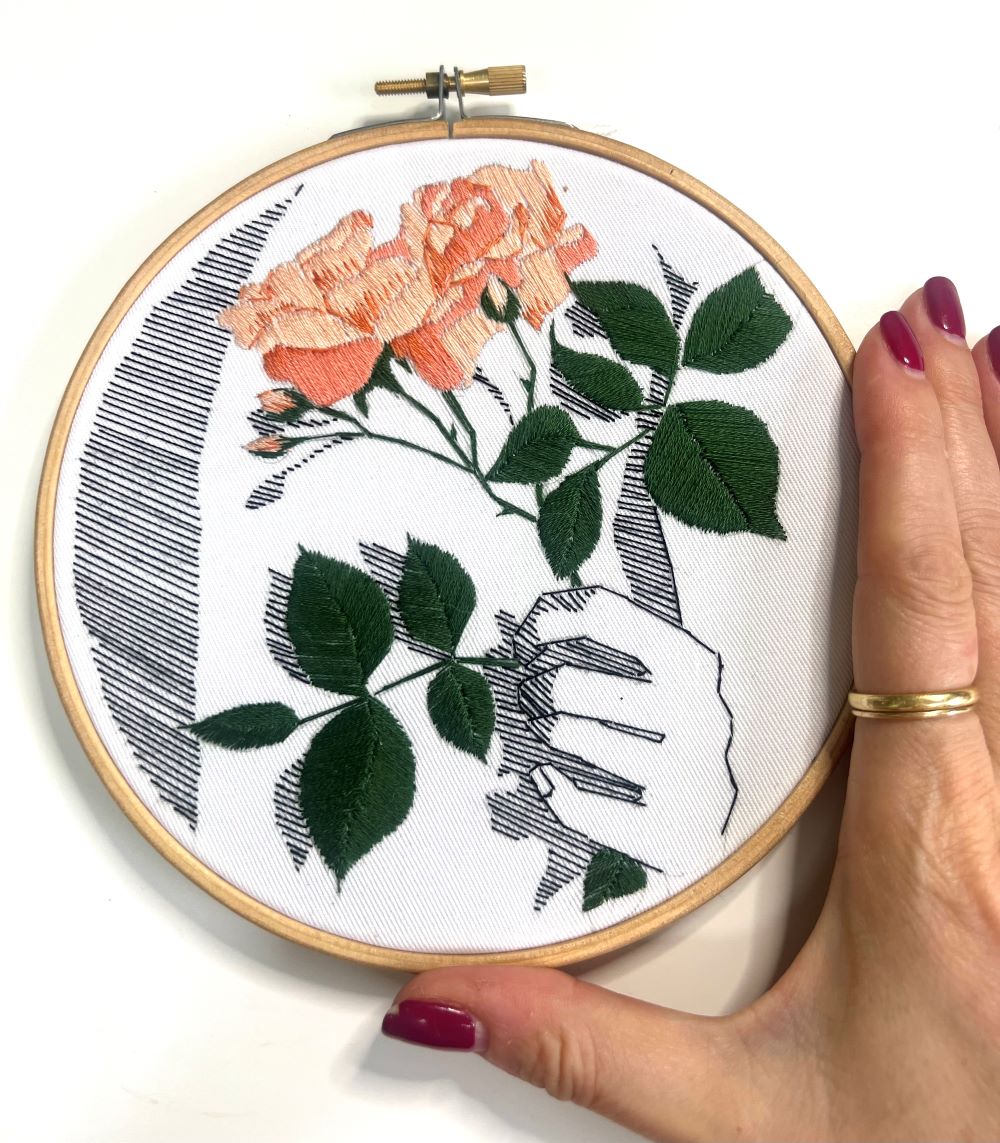 embroidery pattern PDf with floral detail in satin stitch and back stitch with hand detail to show scale