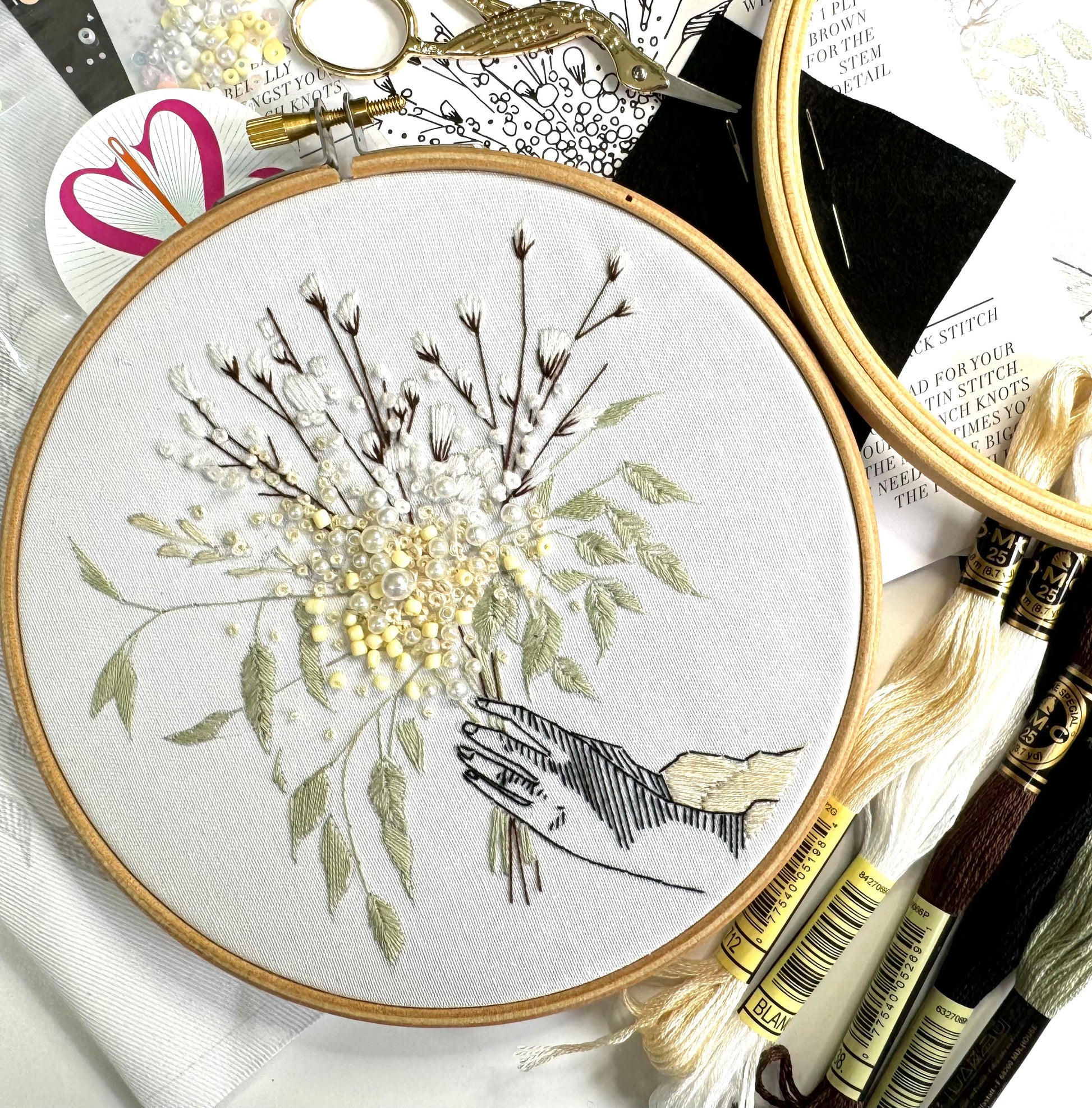 detail of winter embroidery kit with DMC threads and wooden hoop