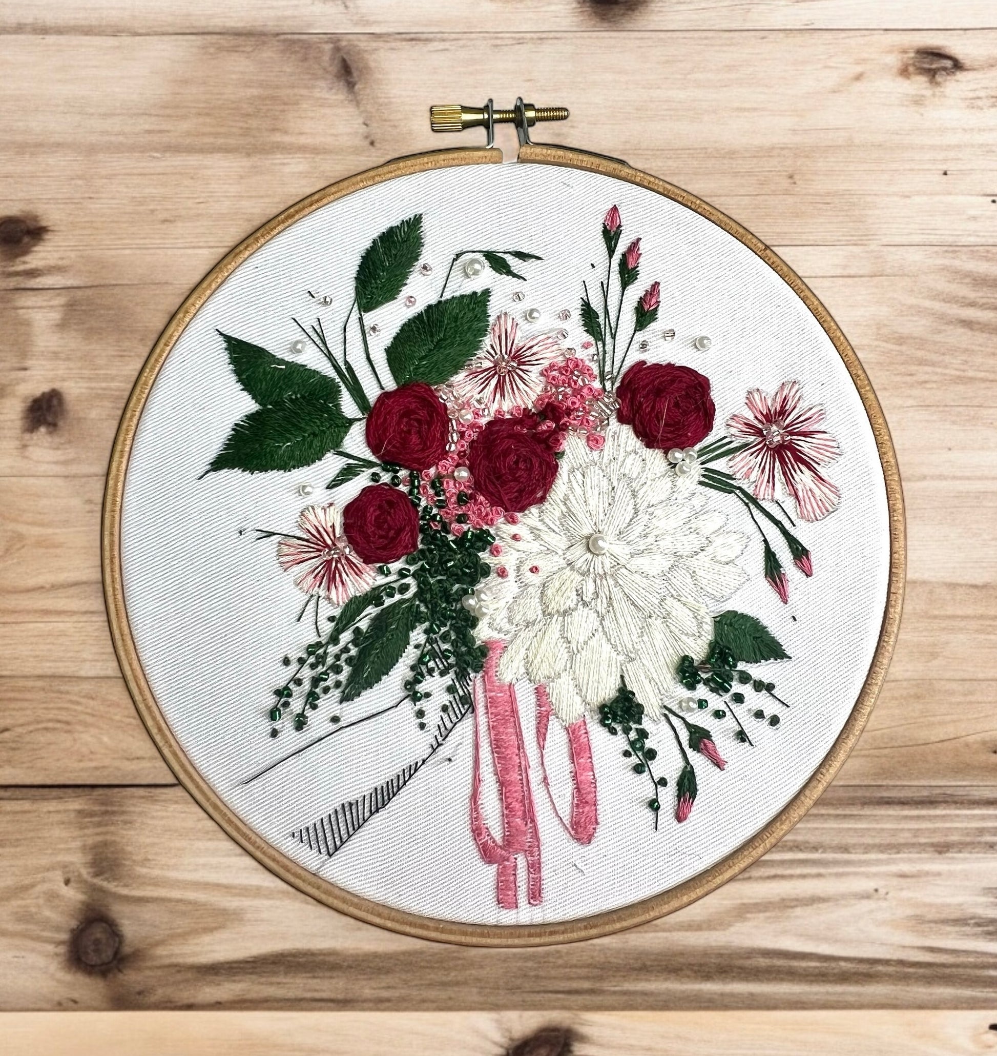 Autumn floral embroidery pattern against wood background 