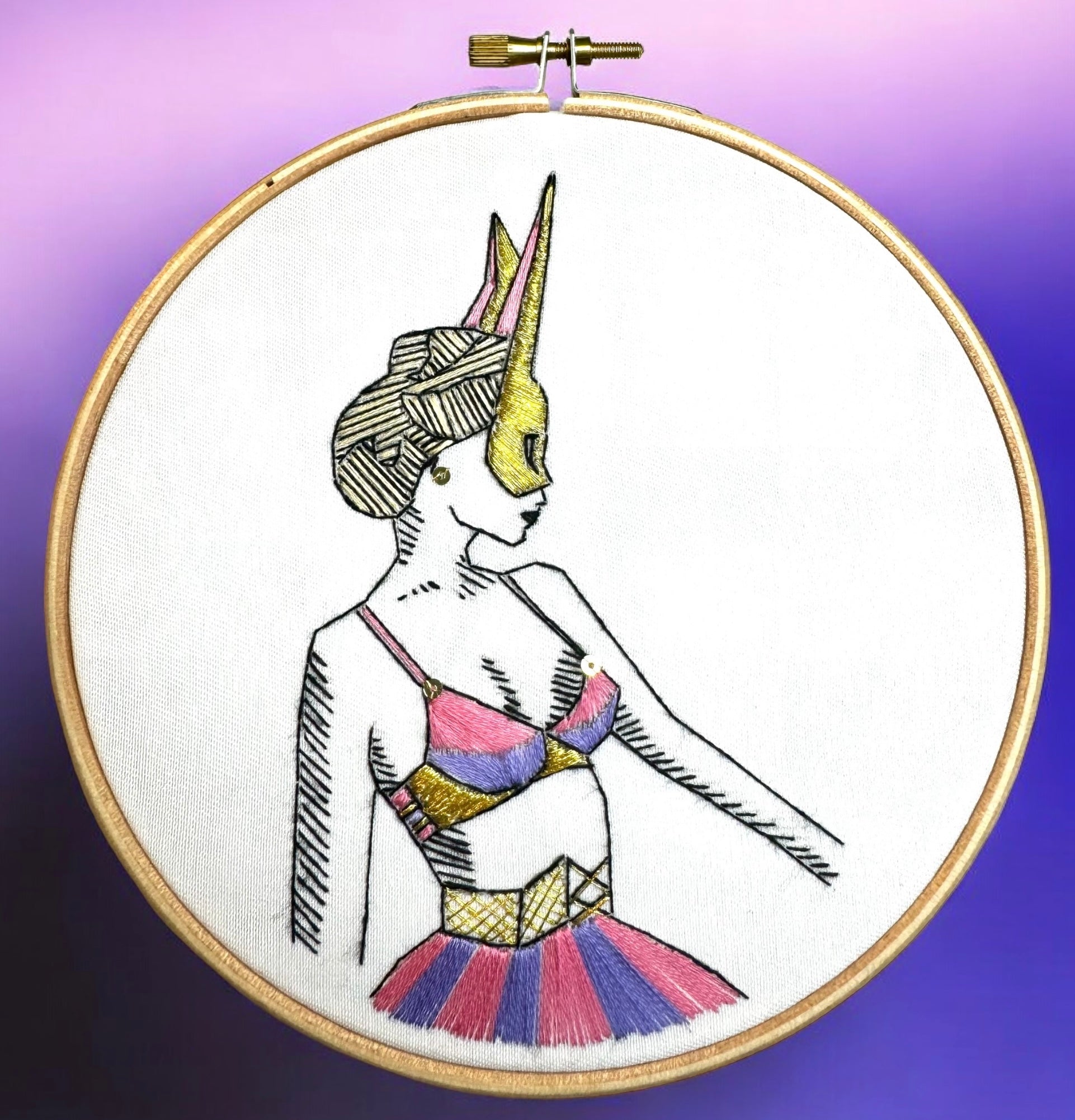 needlepoint pattern with purple background and gold thread detail 