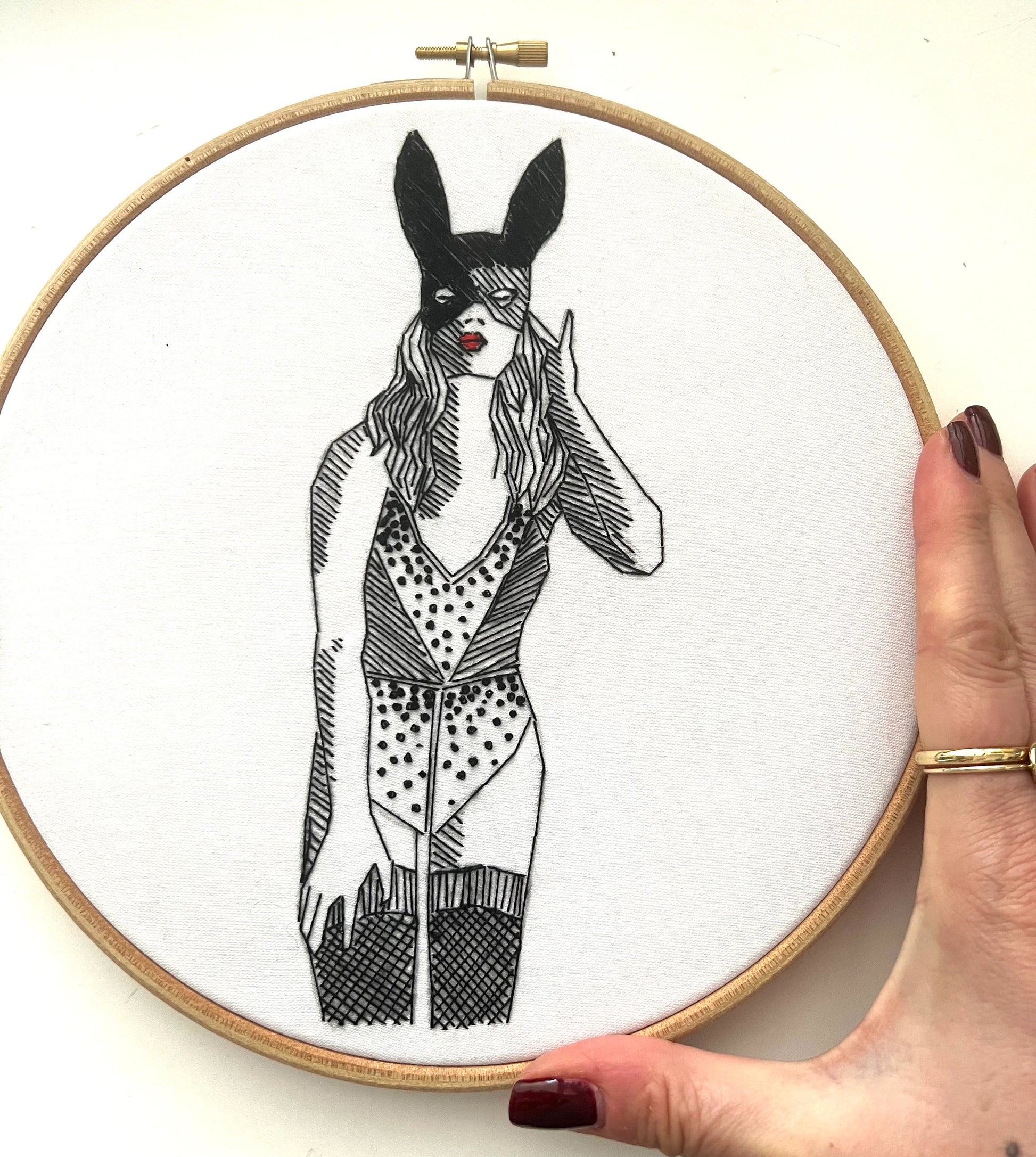 completed beginners embroidery kit in 6 inch hood of woman using black DMC embroidery thread on white cotton
